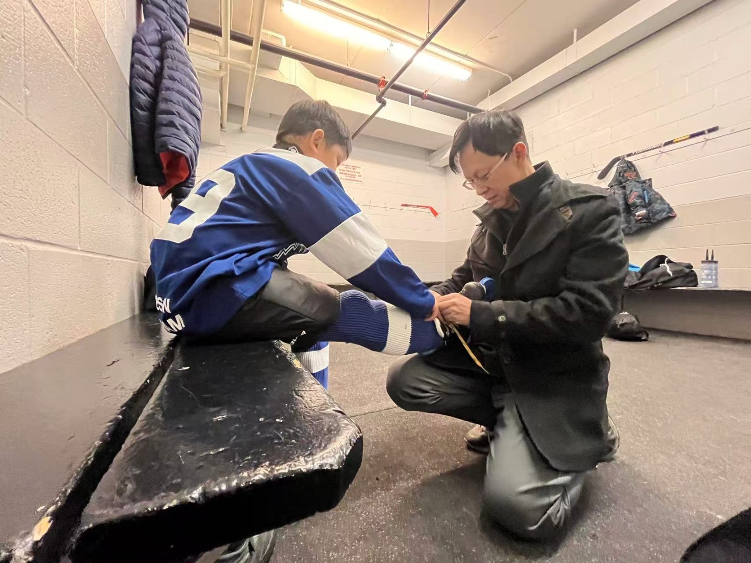 Jack helping a young hockey player in the dressing room